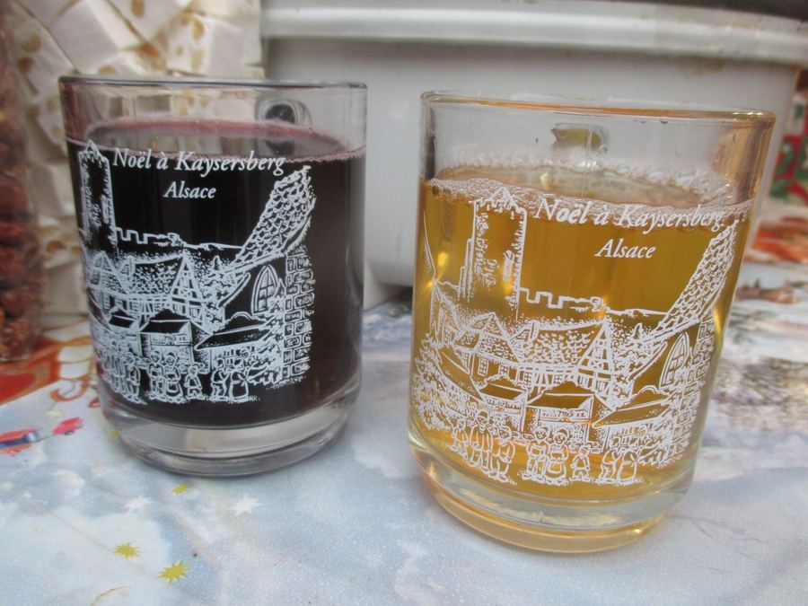 Two printed market glasses from Kaysersberg in Alsace, one holding red mulled wine and one holding white